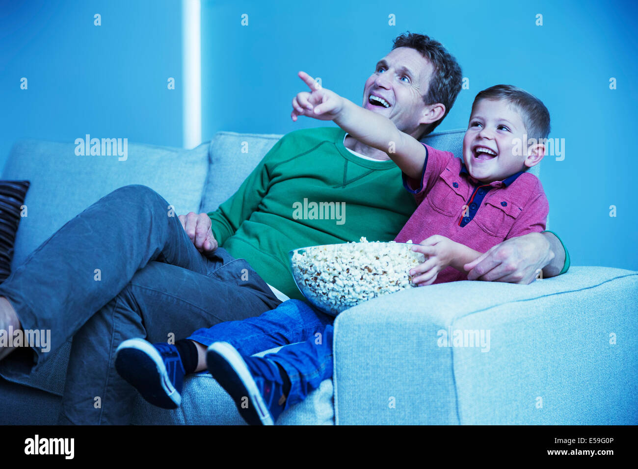 Padre e figlio di guardare la televisione in salotto Foto Stock