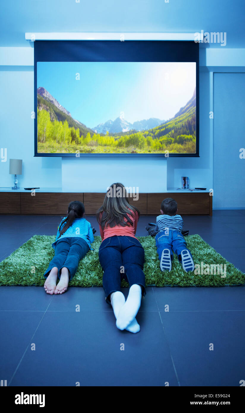 Madre e figli di guardare la televisione in salotto Foto Stock