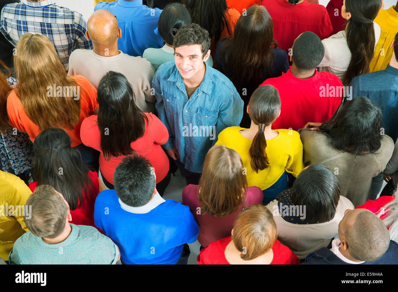 Ritratto di uomo sorridente in piedi fuori dalla folla Foto Stock