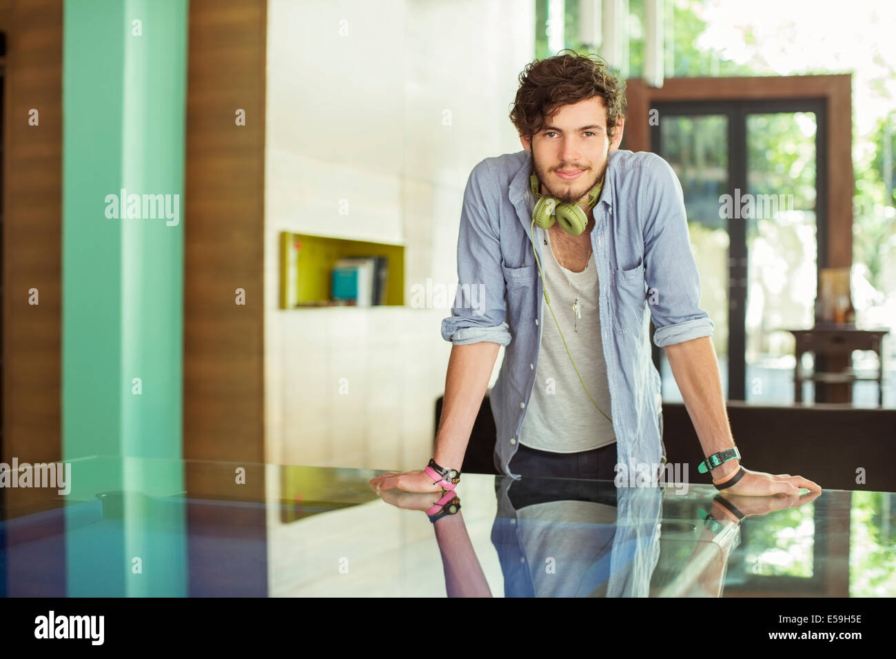 Uomo appoggiato sulla scrivania in ufficio Foto Stock