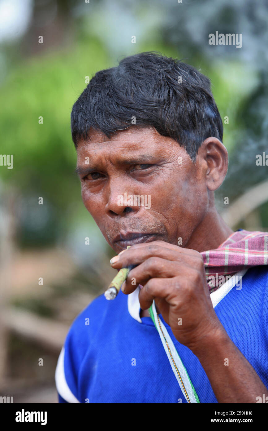 Primo piano di Abhuj Maria uomo tribale che fuma un Chongi (bidi), sigaretta indiana fatta a mano di foglie di sargi, Orrcha. Facce rurali dell'India Foto Stock
