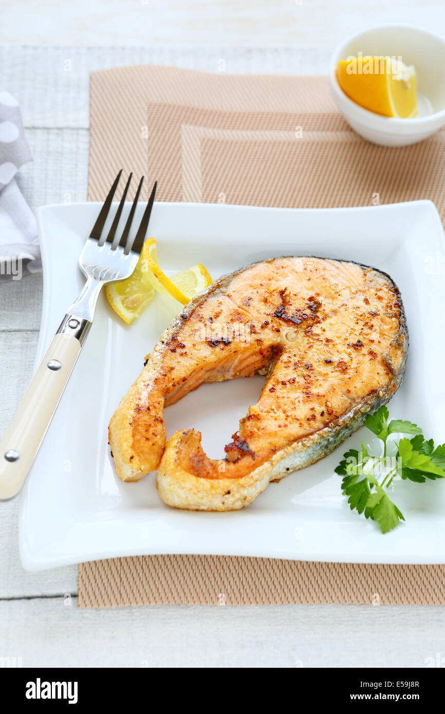 Pesce arrosto su piastra bianca, cibo closeup Foto Stock