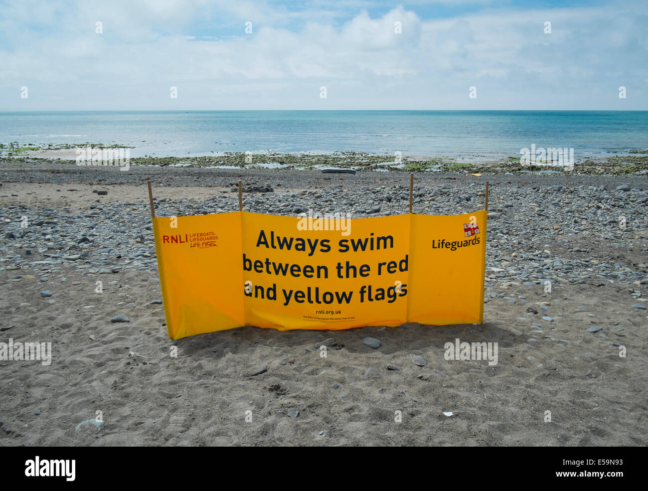 Un segnale di avvertimento da parte del Royal National scialuppa di salvataggio istituzione stazione bagnino su Clarach Bay, Ceredigion, Galles Foto Stock