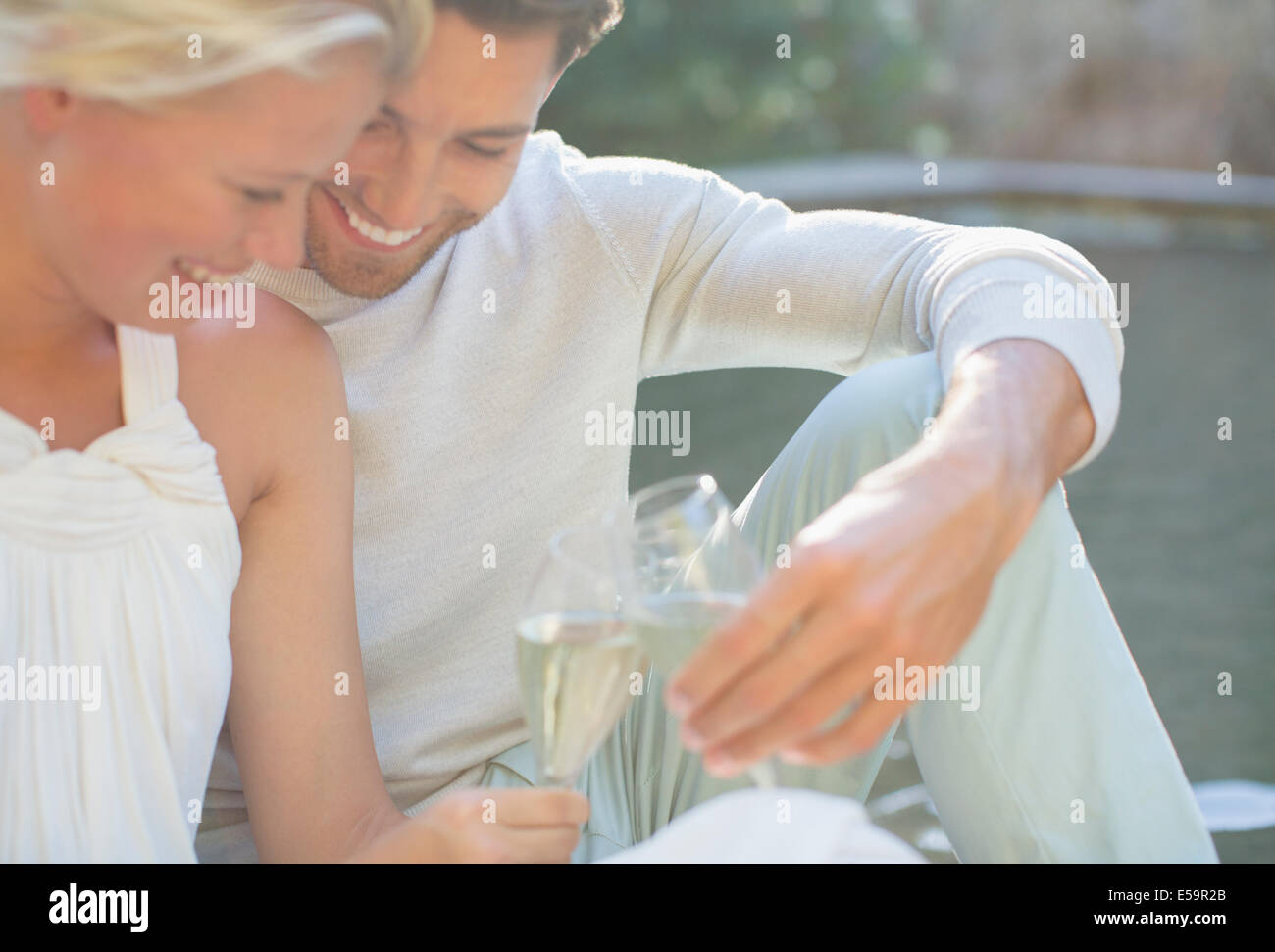 Accoppiare la tostatura a vicenda con champagne all'aperto Foto Stock