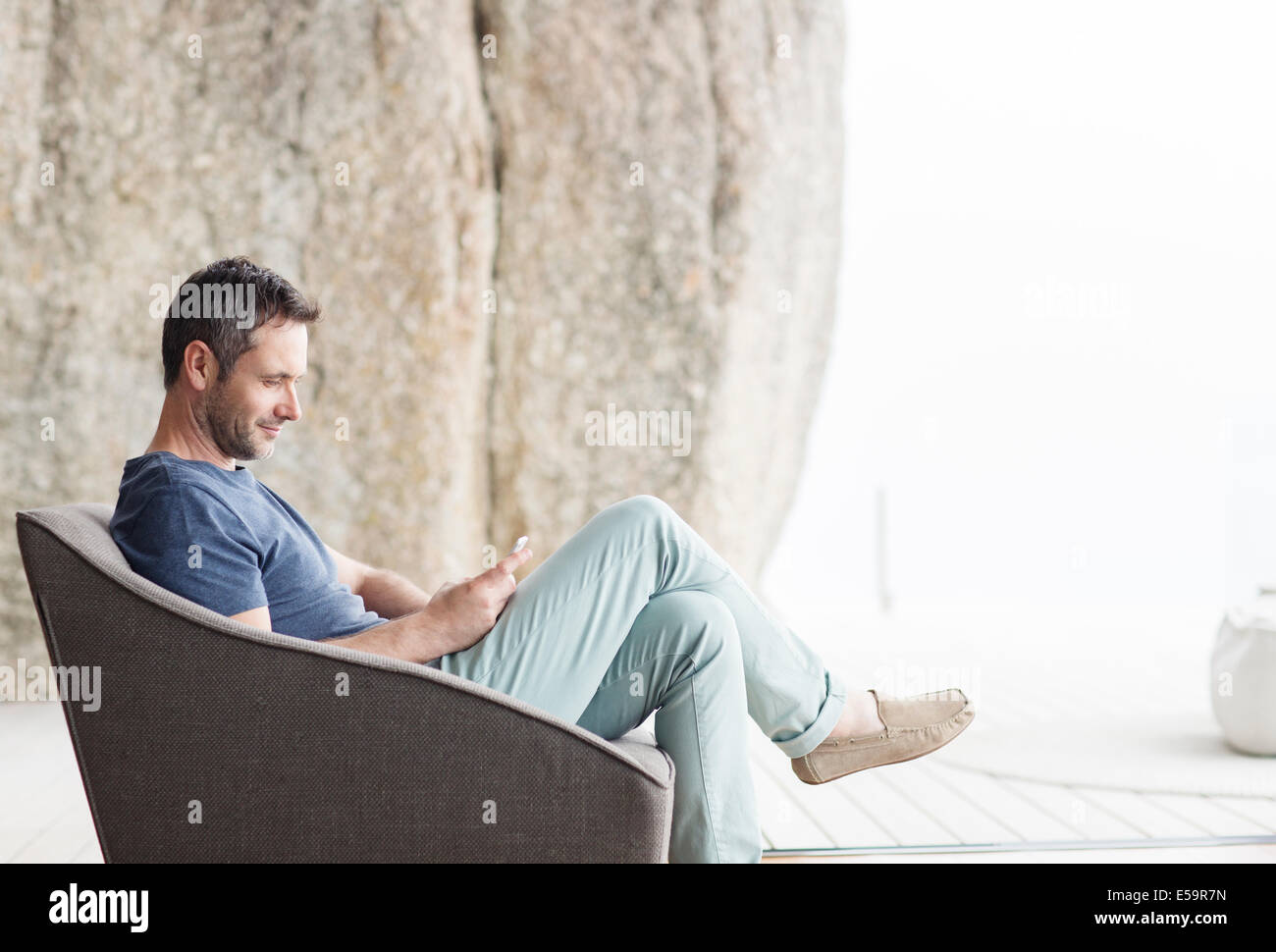 Uomo seduto in poltrona moderna Foto Stock