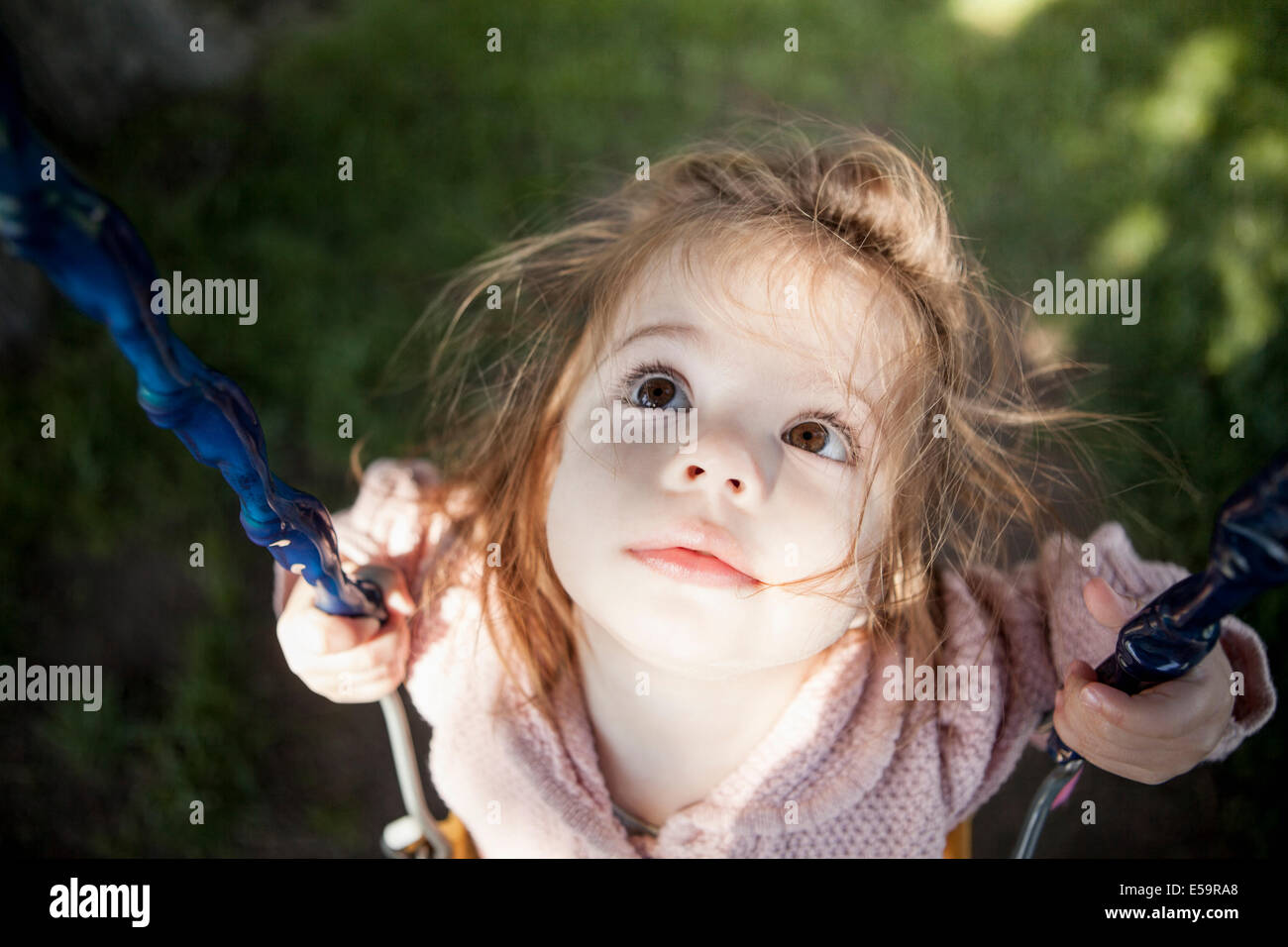 Baby ragazza seduta su swing all'aperto Foto Stock