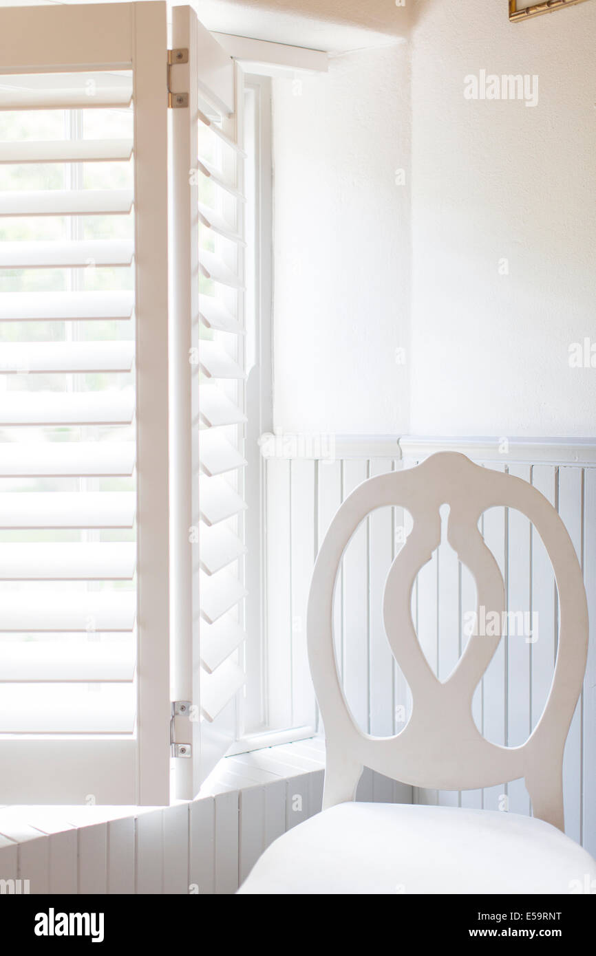 Sedia da finestra con persiane in legno Foto Stock