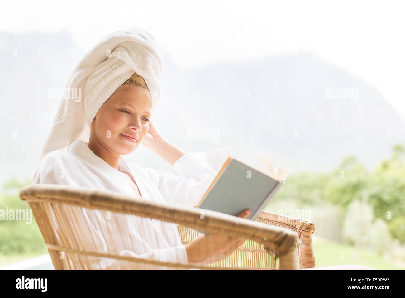 Donna in accappatoio lettura all'aperto Foto Stock