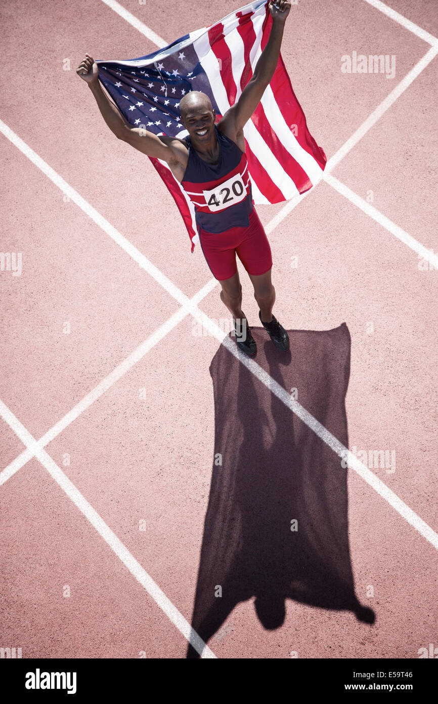 La via e il campo atleta holding bandiera americana sulla via Foto Stock