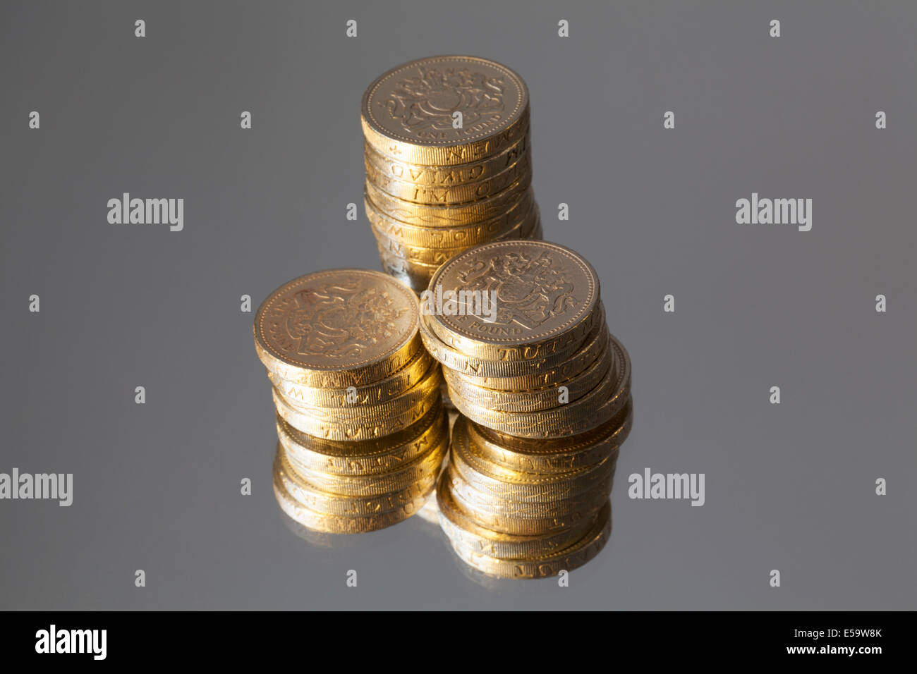 Valuta britannica - colonne di libbra di monete, riflessa in uno specchio. Foto Stock