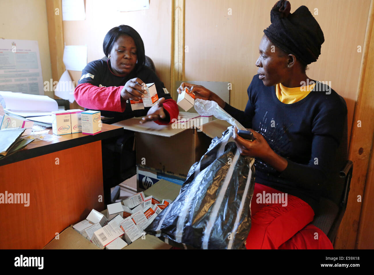 Donna infettate con HIV AIDS (destra) ricevente ARV medicina in una HIV care center di Ndola, Zambia, Africa Foto Stock