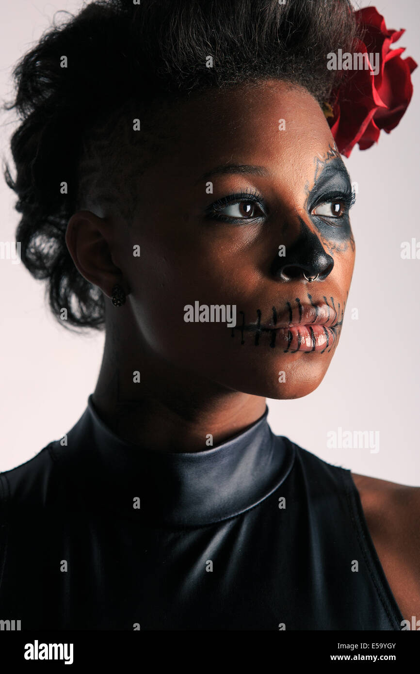 Una giovane donna con vernice faccia a forma di teschio di zucchero decorato per il Dia de los Muertos Foto Stock