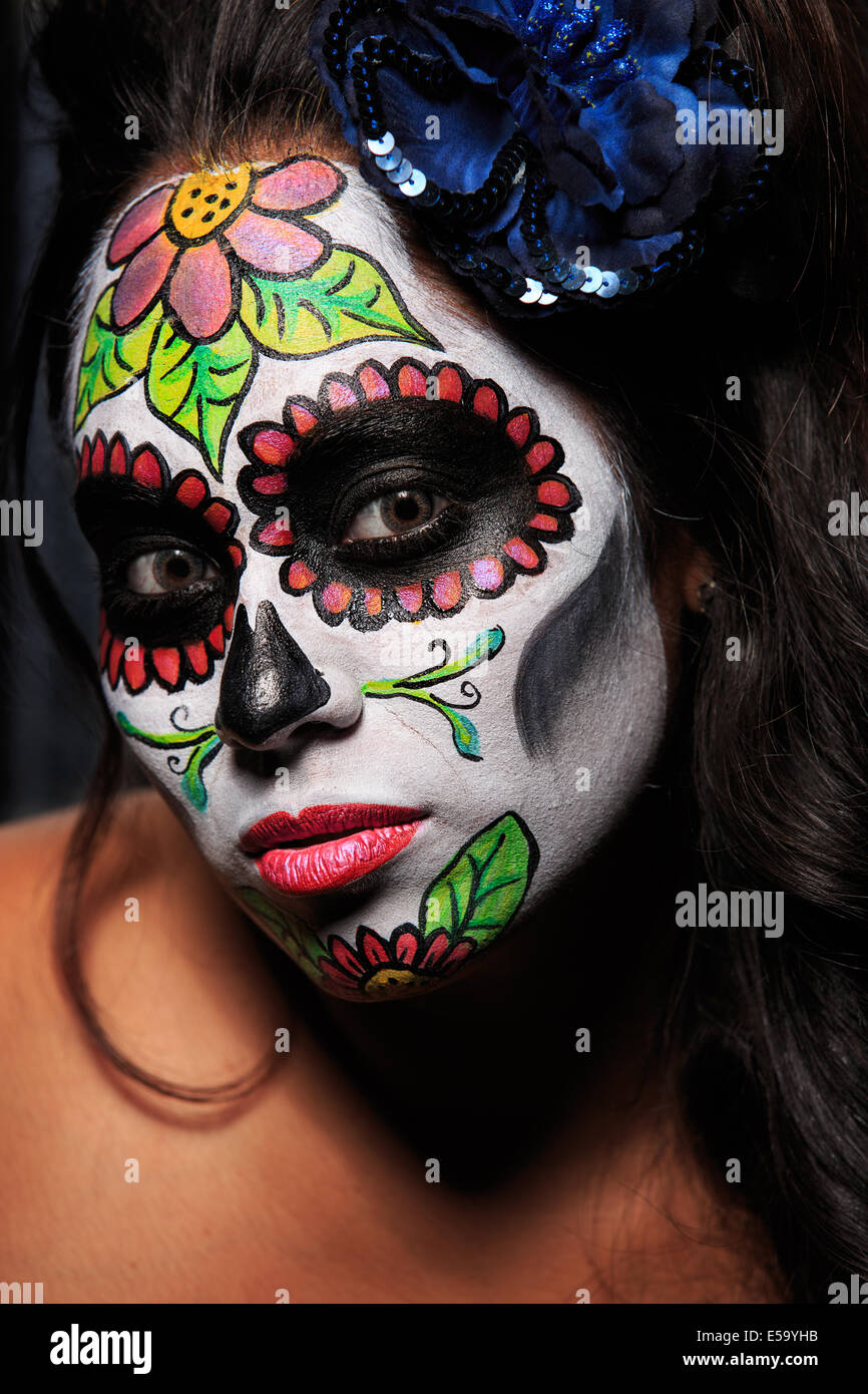 Una giovane donna con vernice faccia a forma di teschio di zucchero decorato per il Dia de los Muertos Foto Stock