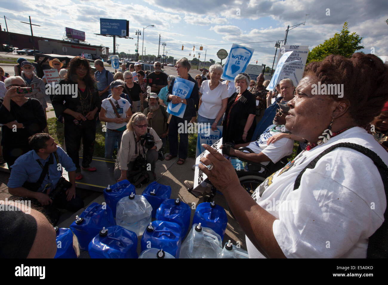 Detroit, Michigan STATI UNITI D'AMERICA - Una delegazione del Canada acqua erogata a Detroit come una protesta contro la città di shutoffs d'acqua. Come si tenta di recuperare dal fallimento, la città è intercettazione acqua a decine di migliaia di persone che vivono in condizioni di povertà che sono dietro a loro fatture. Lila Cabbil del popolo della scheda di acqua parla dopo acqua è consegnata al San Pietro Chiesa Episcopale, un sito in cui i residenti possono prelevare acqua se il loro servizio è stato spento. Foto Stock