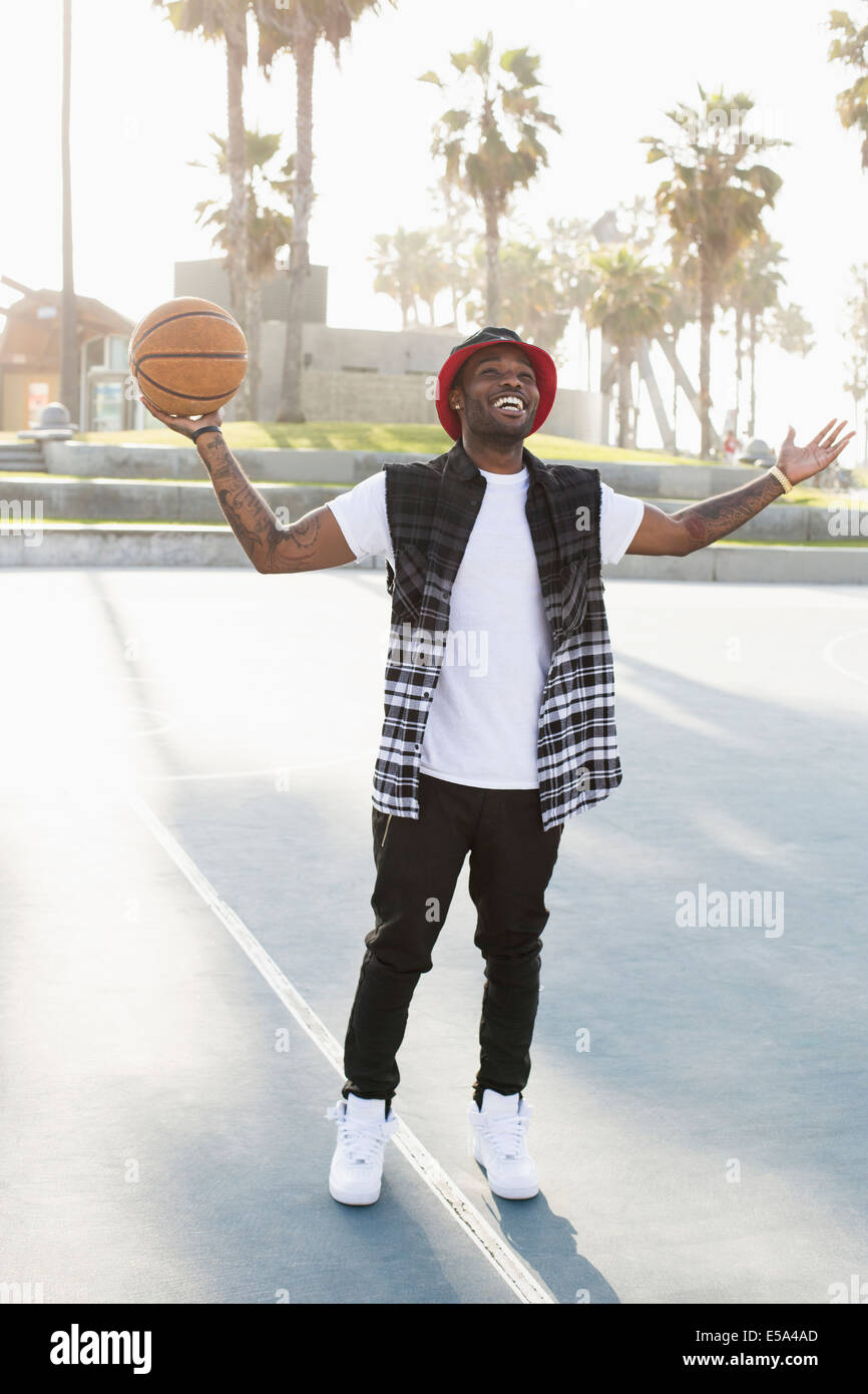 African American uomo in piedi sul campo di pallacanestro Foto Stock