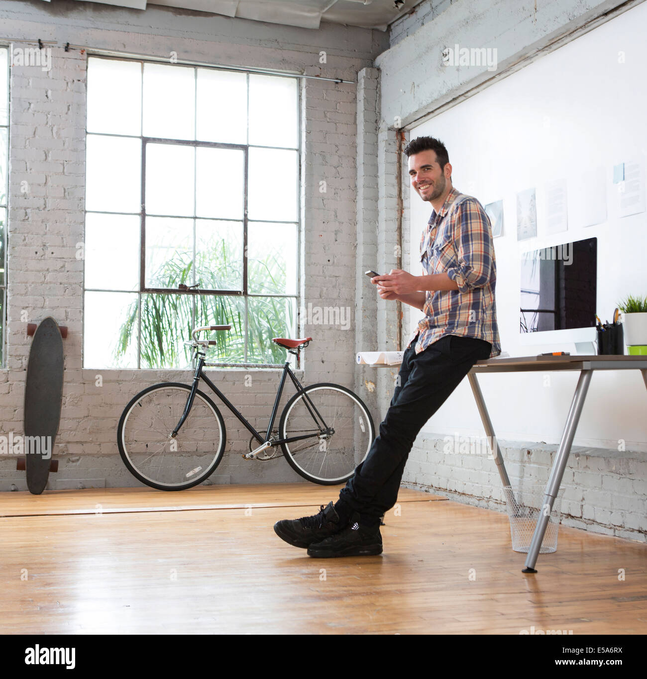 Architetto caucasica utilizzando il cellulare in ufficio Foto Stock