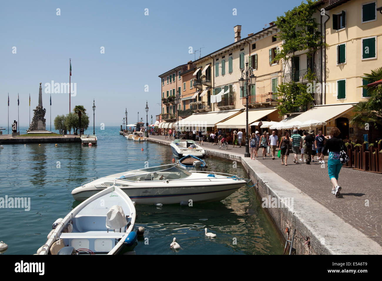I turisti a camminare lungo il porto nel villaggio di Lazise, sul Lago di Garda, Italia. Foto Stock