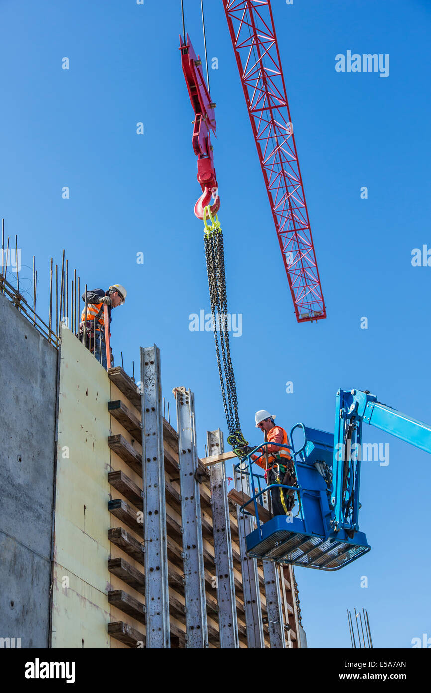 Lavoratori su parete in calcestruzzo modulo sul sito in costruzione Foto Stock