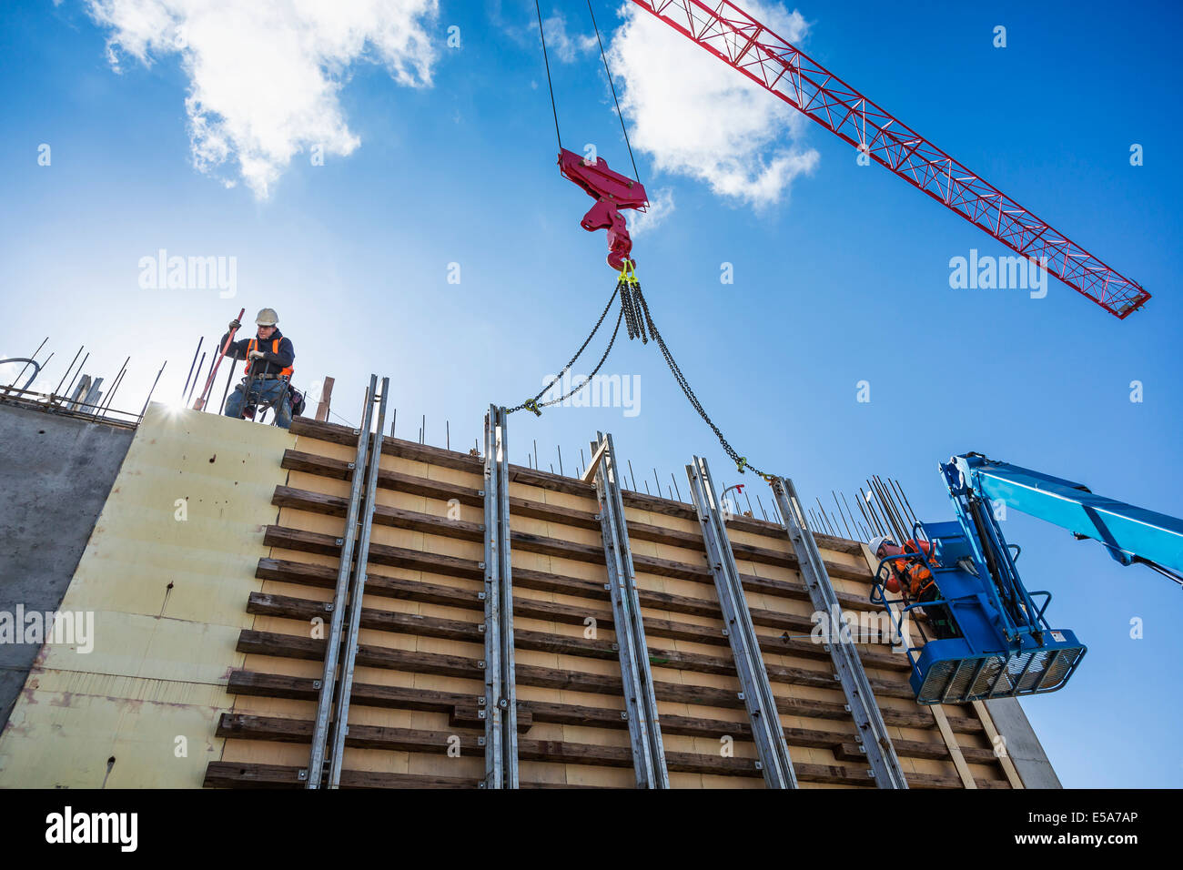 Lavoratori su parete in calcestruzzo modulo sul sito in costruzione Foto Stock