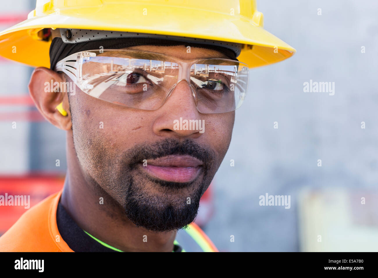 Lavoratore nero sorridente sul sito in costruzione Foto Stock