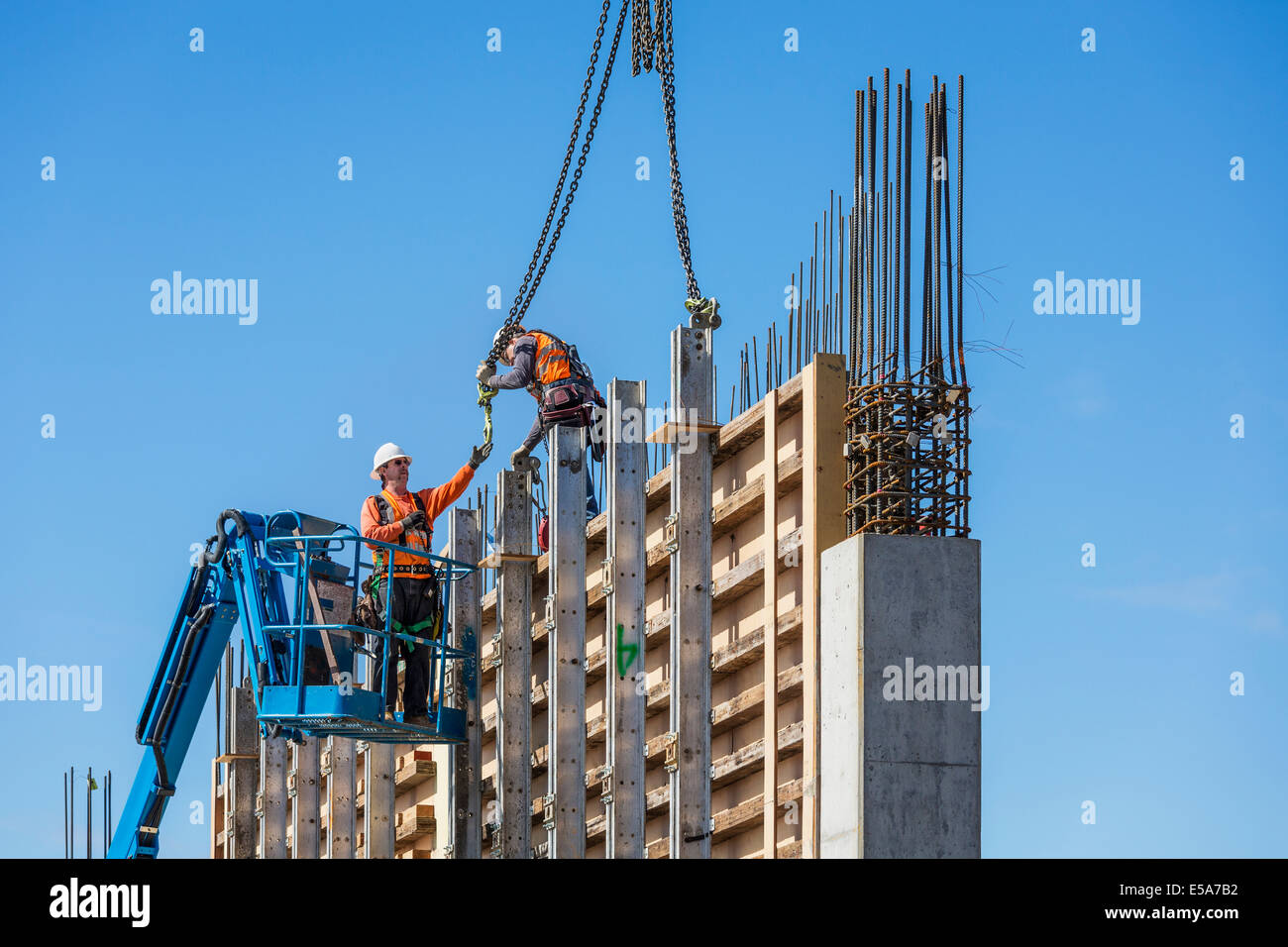 Lavoratori su parete in calcestruzzo modulo sul sito in costruzione Foto Stock
