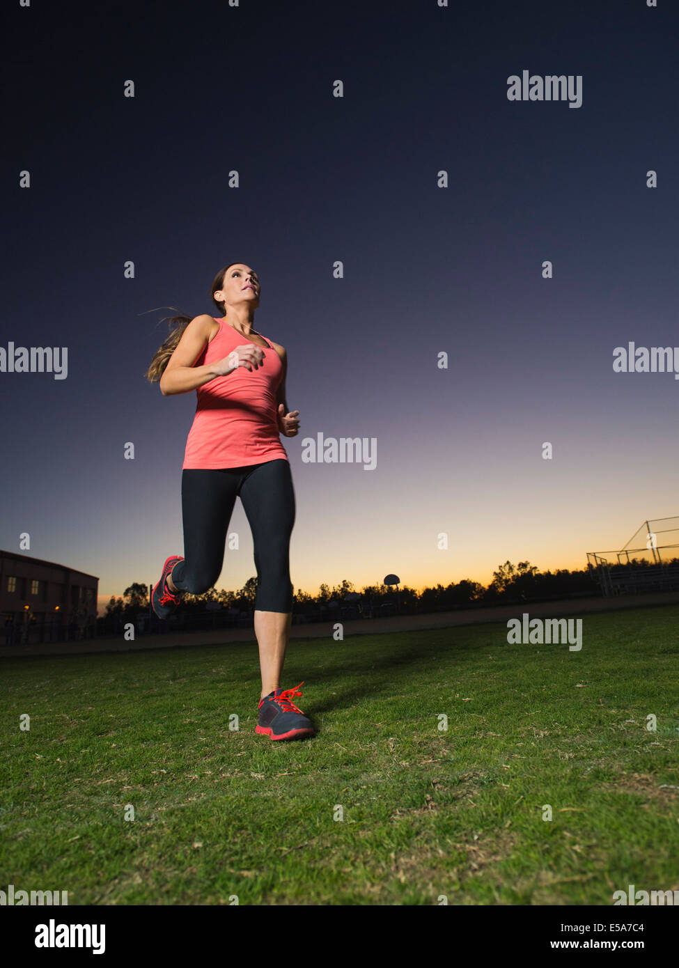 La donna caucasica jogging all'aperto presso sunrise Foto Stock