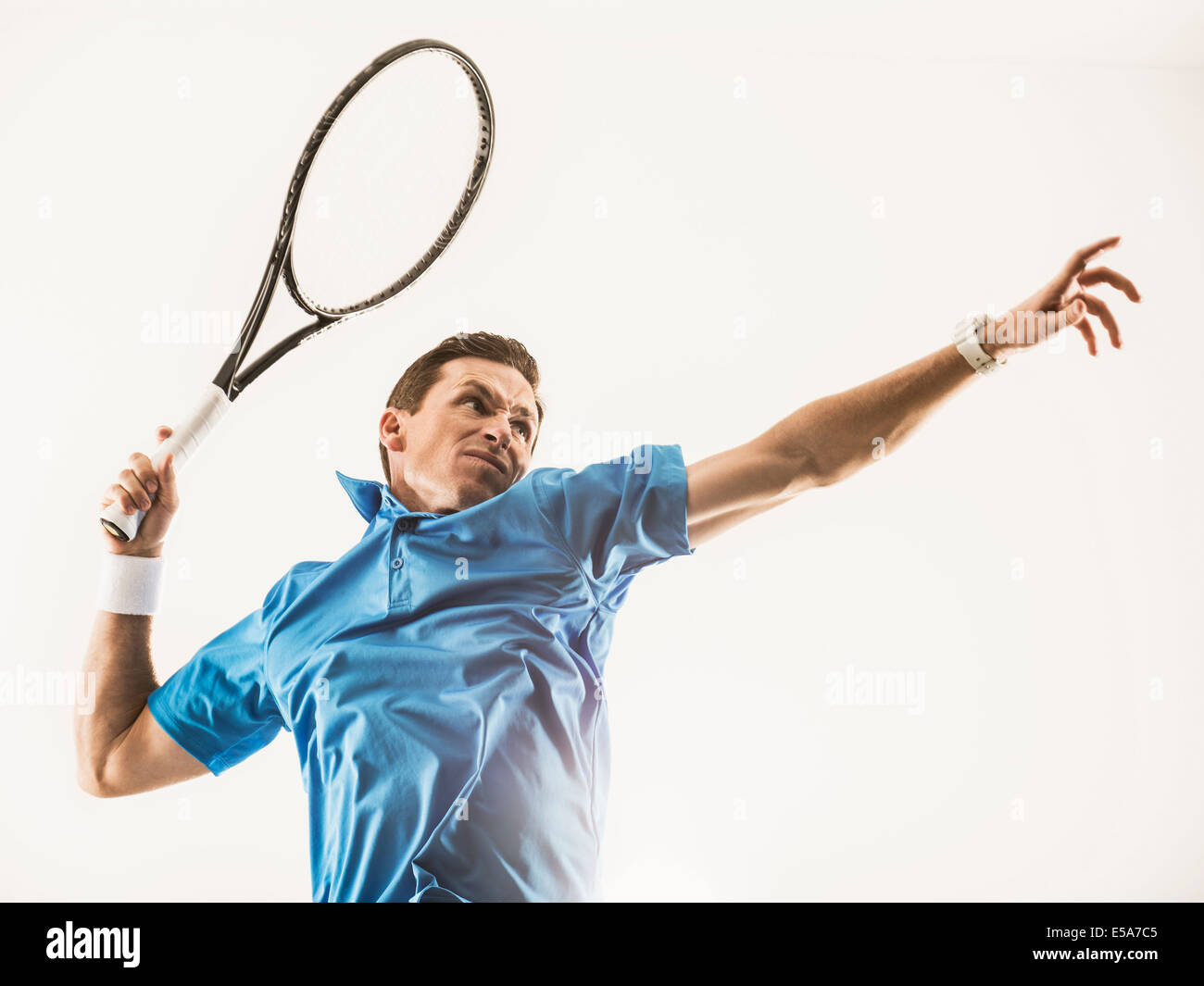 Uomo caucasico giocando a tennis Foto Stock