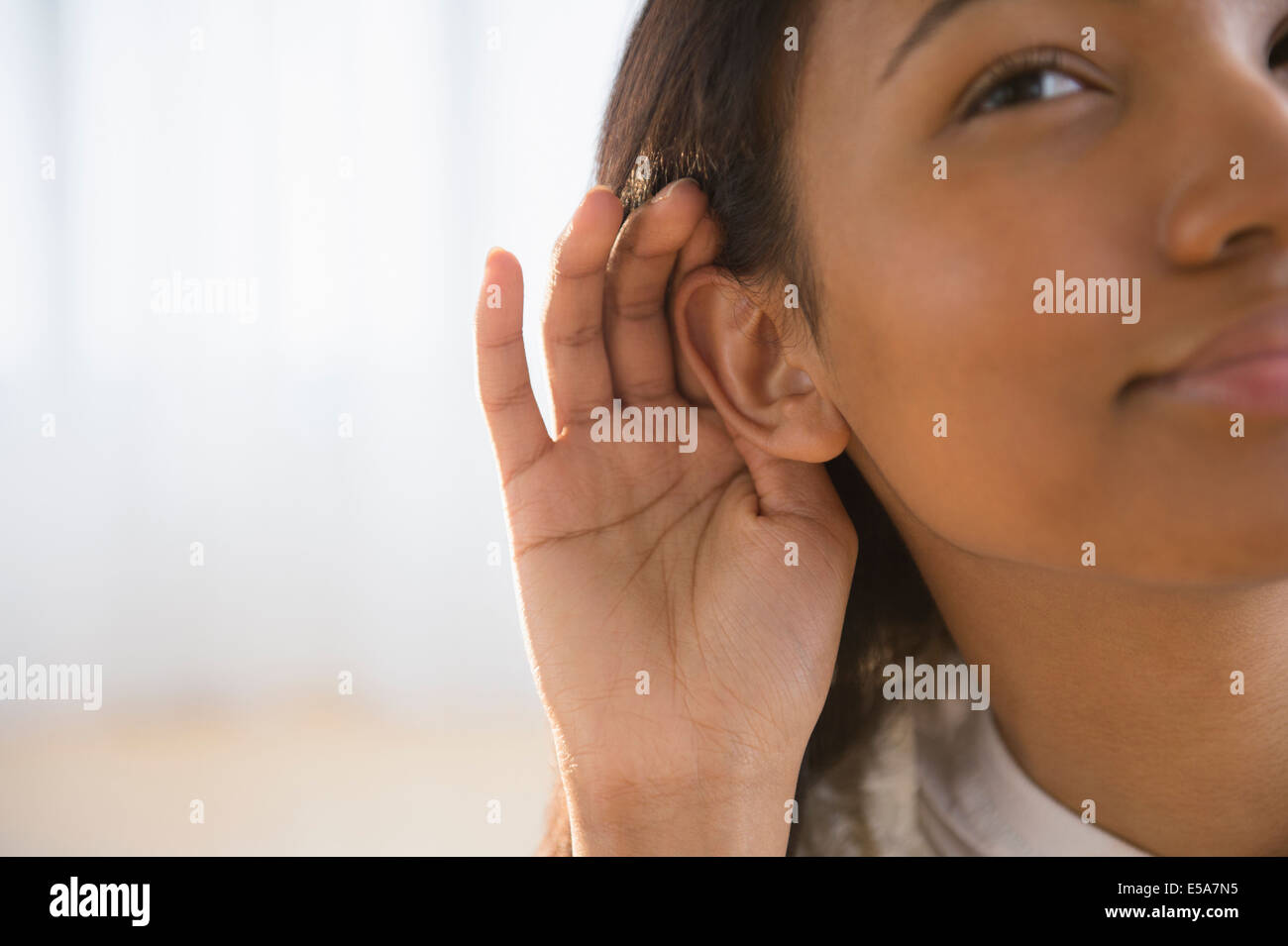 Razza mista donna coppettazione her ear Foto Stock