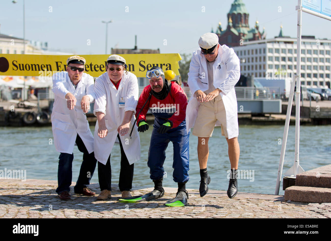 Helsinki, Finlandia. Luglio 25, 2014. Membri della Finlandia è privo di fondamento scientifico della Società preparare per il lancio della Pietra Fredda nella piscina del colera di Helsinki a sud del porto. Secondo una vecchia tradizione finlandese, Jaakko getta una pietra fredda in un lago su Jaakko di denominazione del giorno, 25 luglio. Questo presumibilmente si raffredda acque, segna la fine dell'estate. Giorno originale segnando il raffreddamento delle acque è effettivamente ancora un paio di settimane di riposo. Questo è dovuto al fatto che lo switch di Julian per il calendario gregoriano nella metà del XVIII secolo. Credito: Aija Lehtonen/Alamy Live News Foto Stock