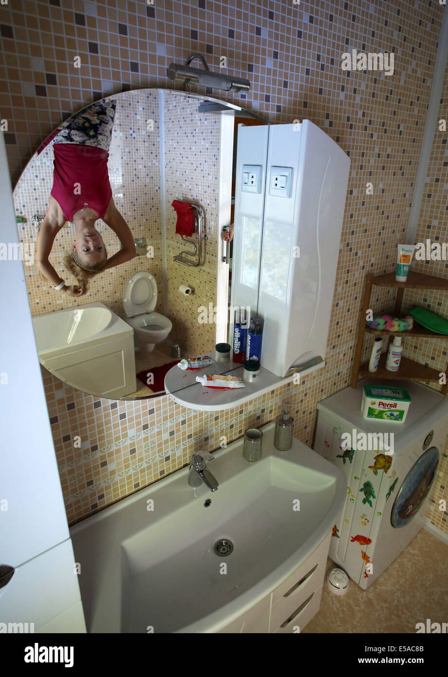 San Pietroburgo, Russia. Xxv Luglio, 2014. A San Pietroburgo, ha trasformato la casa. La proprietà è una casa, dove i visitatori possono camminare sul soffitto, guardare il mondo da una diversa angolazione, per fare alcune foto meravigliose. La casa dispone di numerose camere: soggiorno, camera dei bambini, camera da letto, cucina e bagno. Gli ospiti della casa rientrano in una nuova realtà. Mobili da pranzo, utensili, gli arredi sono capovolti. Varcare la soglia, non ha immediatamente utilizzati per ottenere l'insolito entourage: il pavimento diventa il soffitto e il letto e lampade appese in aria. Credito: ZUMA Press, Inc./Alamy Live ne Foto Stock