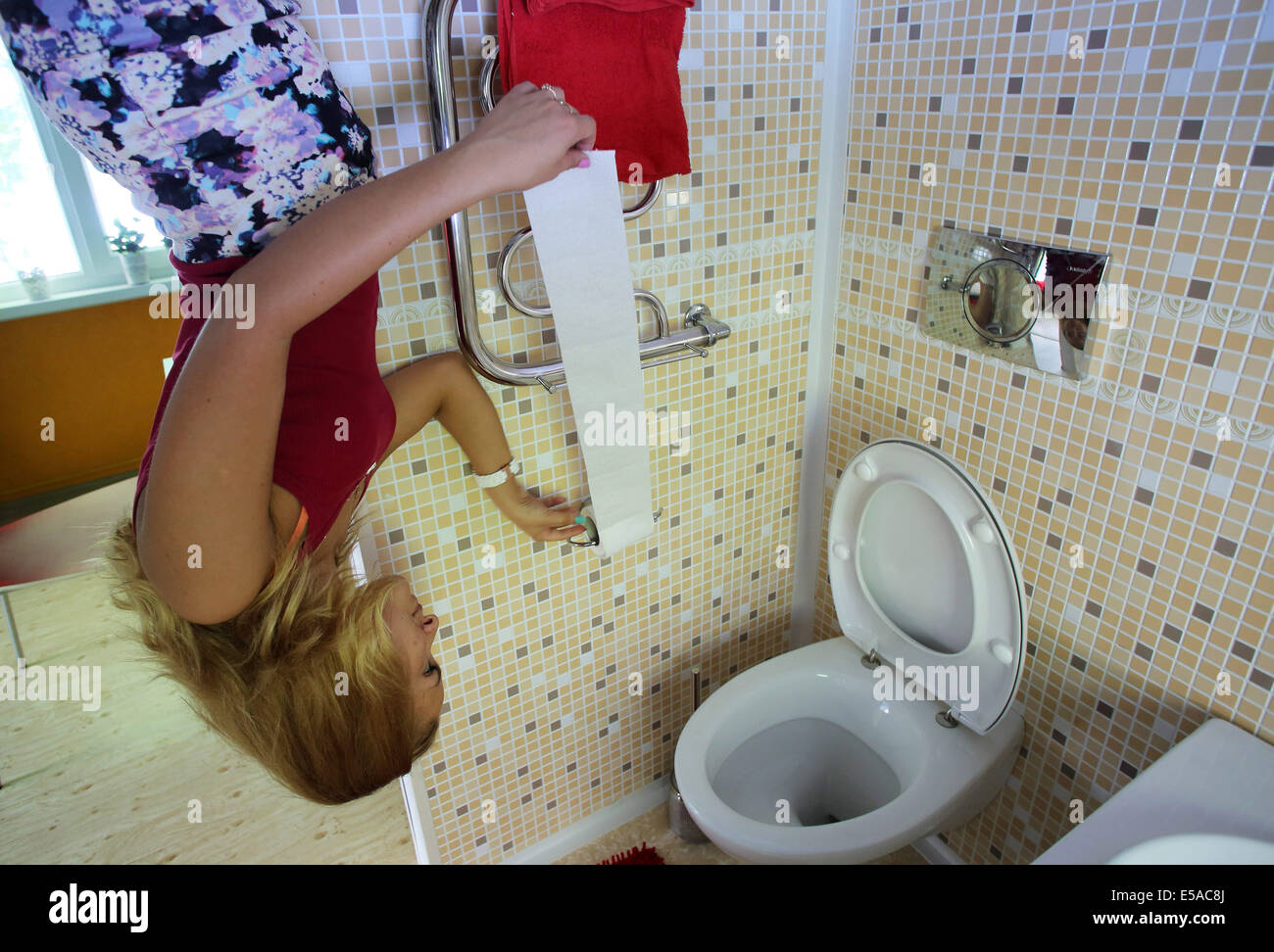 San Pietroburgo, Russia. Xxv Luglio, 2014. A San Pietroburgo, ha trasformato la casa. La proprietà è una casa, dove i visitatori possono camminare sul soffitto, guardare il mondo da una diversa angolazione, per fare alcune foto meravigliose. La casa dispone di numerose camere: soggiorno, camera dei bambini, camera da letto, cucina e bagno. Gli ospiti della casa rientrano in una nuova realtà. Mobili da pranzo, utensili, gli arredi sono capovolti. Varcare la soglia, non ha immediatamente utilizzati per ottenere l'insolito entourage: il pavimento diventa il soffitto e il letto e lampade appese in aria. Credito: ZUMA Press, Inc./Alamy Live ne Foto Stock