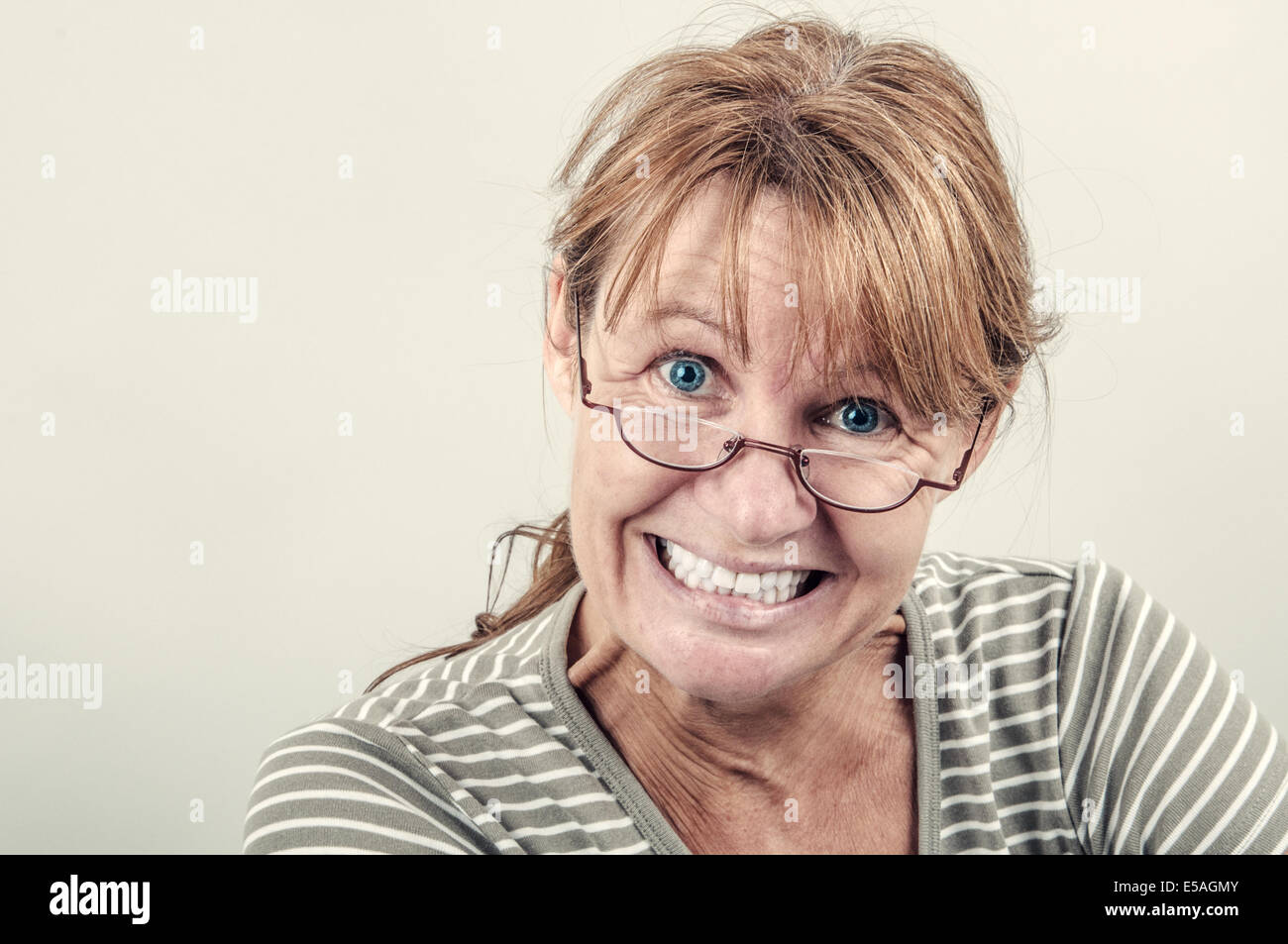 Ritratto di un divertente smorfie donna naturale con gli occhiali da lettura Foto Stock