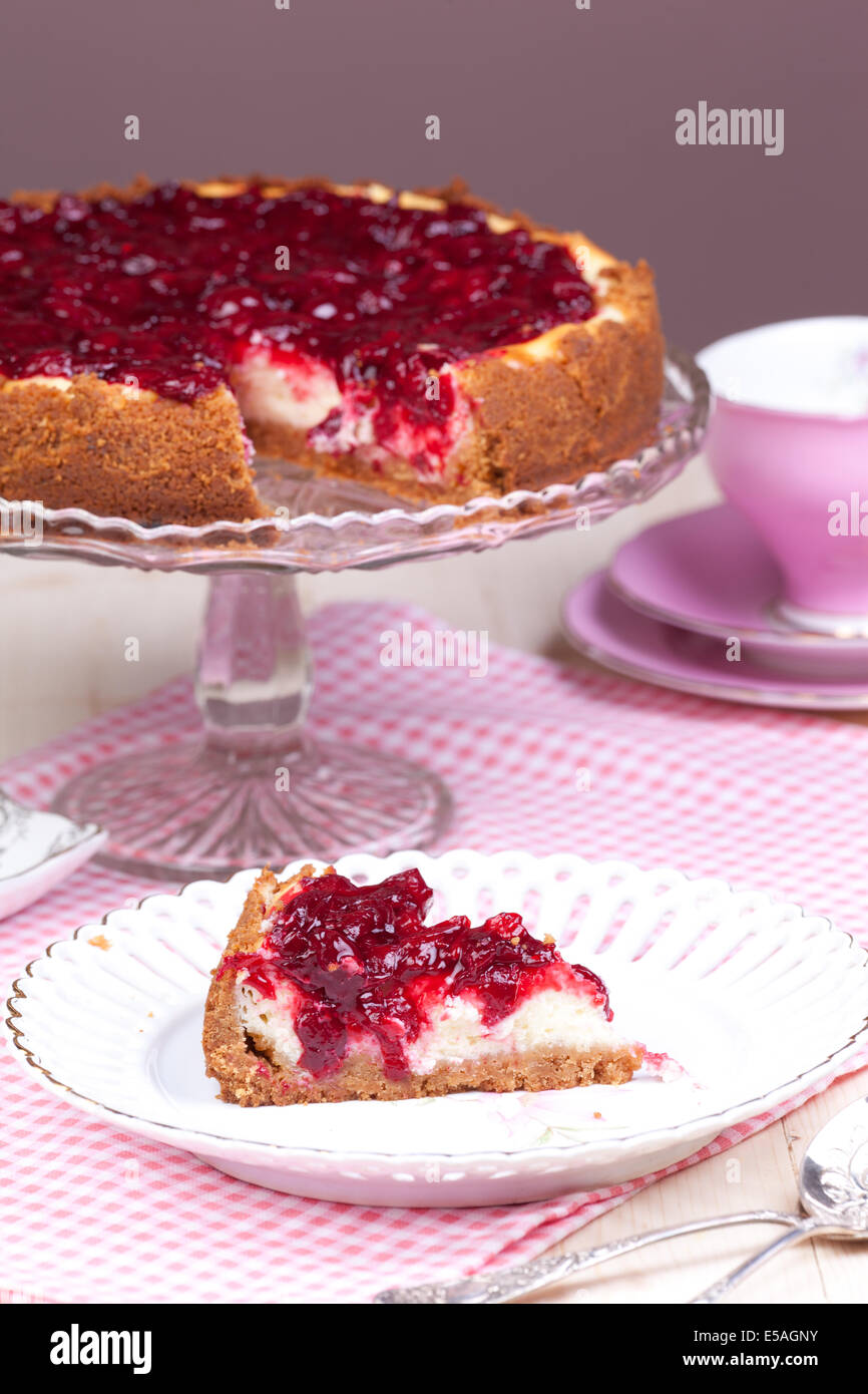 Tagliare il pezzo di ciliegia cheesecake Foto Stock