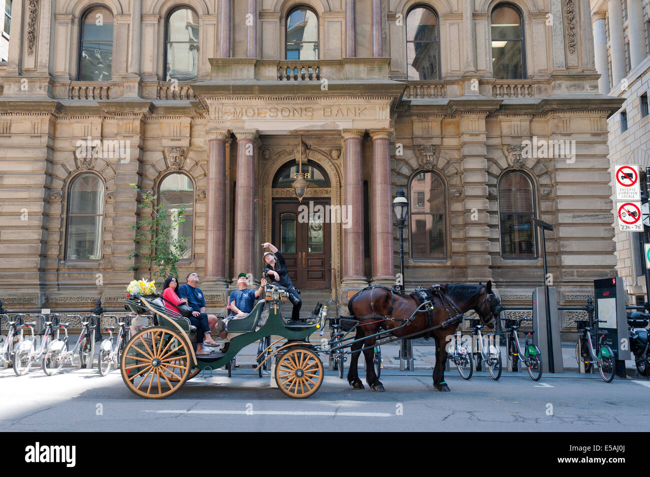 Un carro trainato da cavalli tour in Old Montreal. Il driver è di descrivere gli edifici circostanti ai suoi clienti. Foto Stock