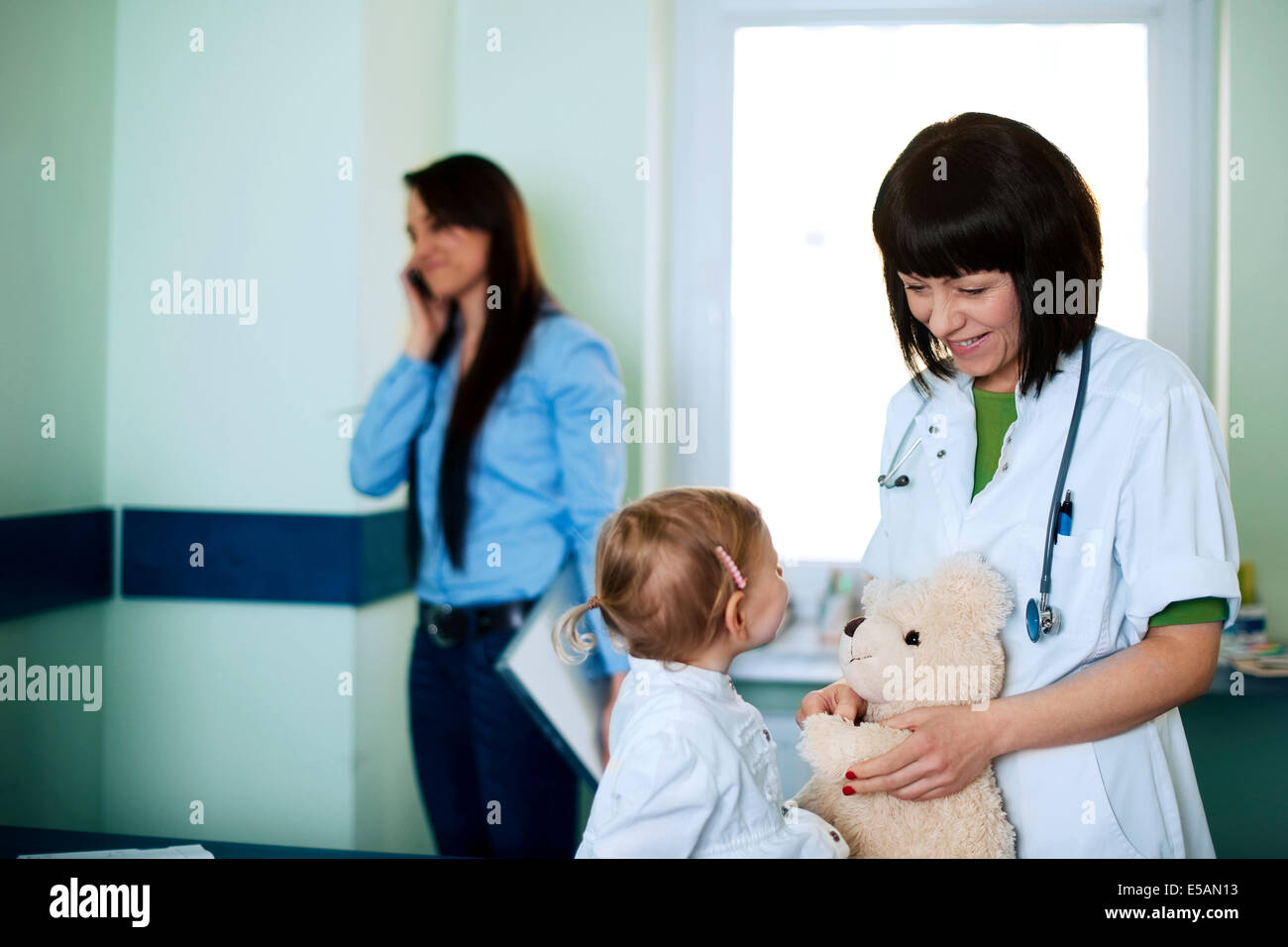 Occupato imprenditrice tenendo la propria figlia per il medico, Debica, Polonia Foto Stock