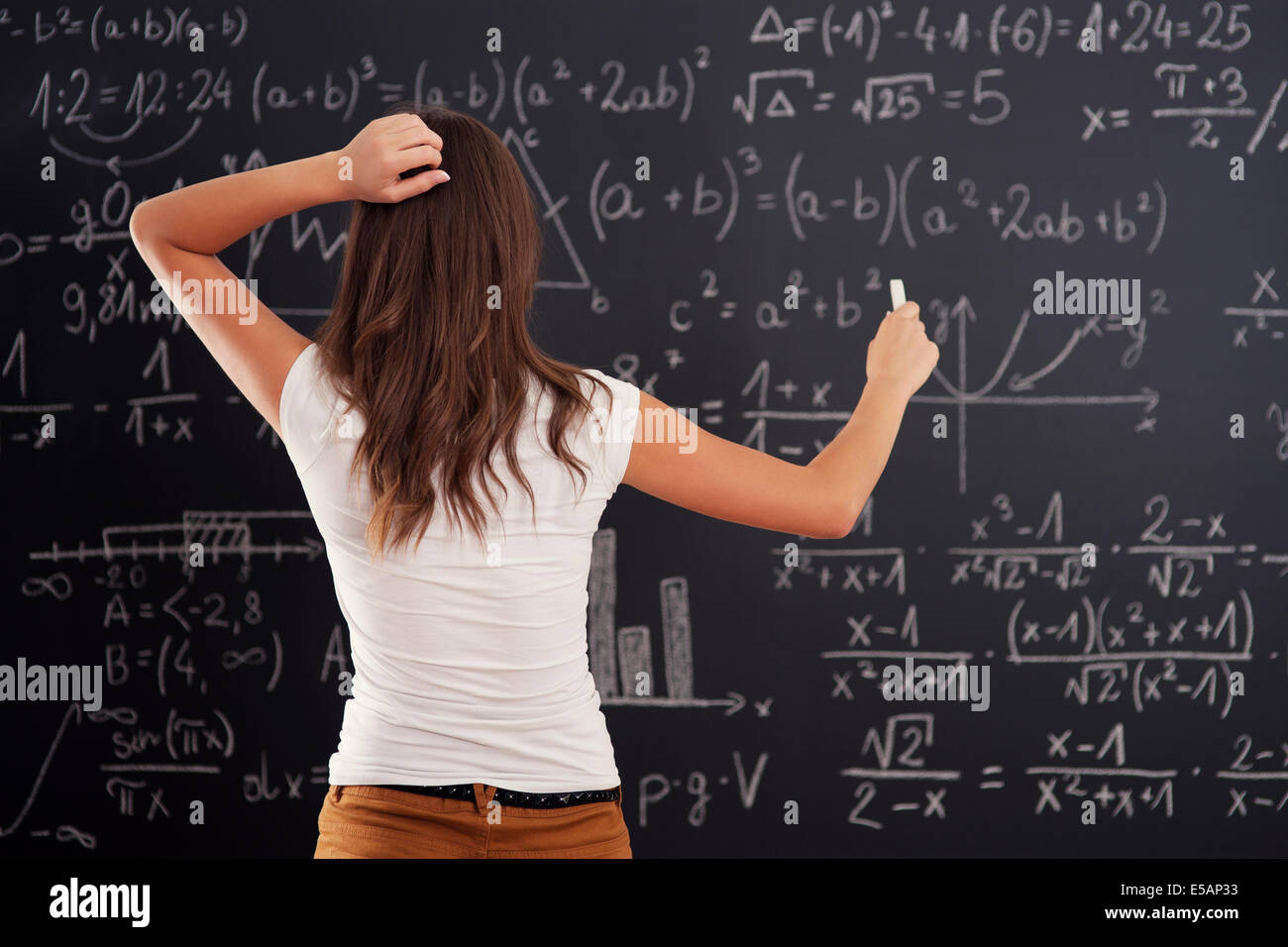 Giovane donna che guarda al problema di matematica sulla lavagna Debica, Polonia Foto Stock