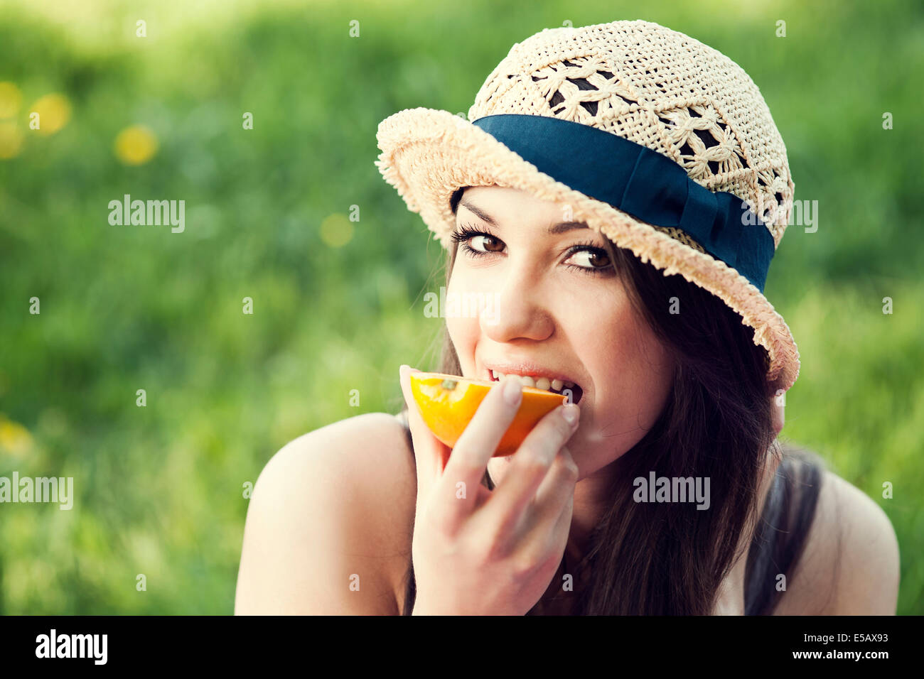 Bella donna mangiare arancione sul prato Debica, Polonia Foto Stock