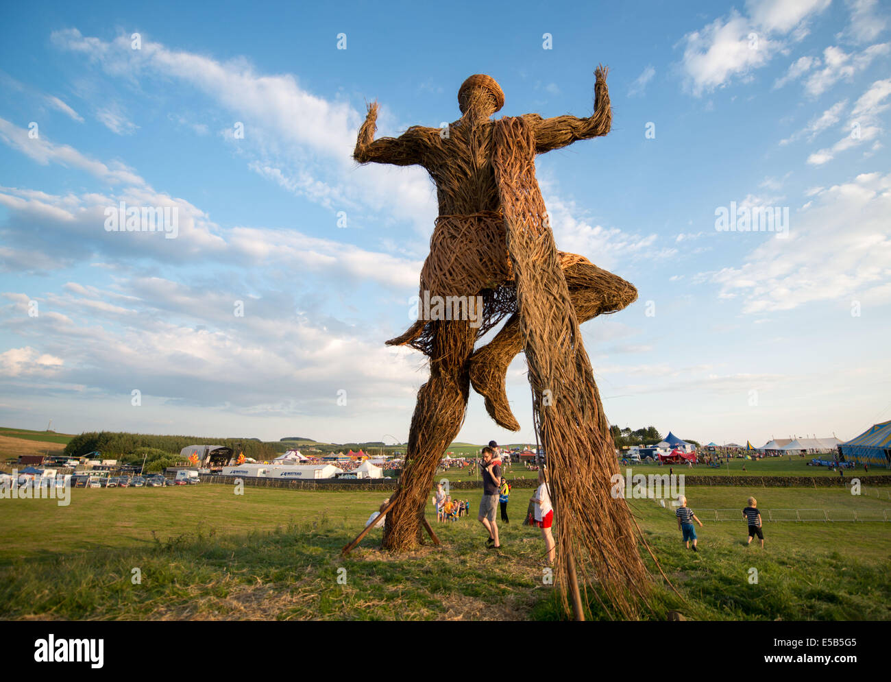 Dumfries, Scotland, Regno Unito. Xxv Luglio, 2014. I frequentatori del festival si raccolgono sotto la Wickerman il giorno uno a Dundrennan sulla luglio 25, 2014 a Dumfries, Regno Unito. Credito: Sam Kovak/Alamy Live News Foto Stock