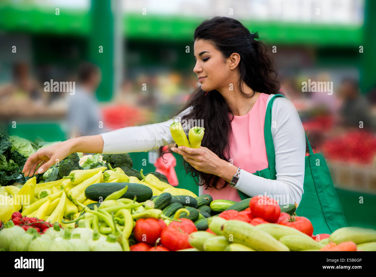 Piuttosto giovane donna acquistare verdure sul mercato Foto Stock
