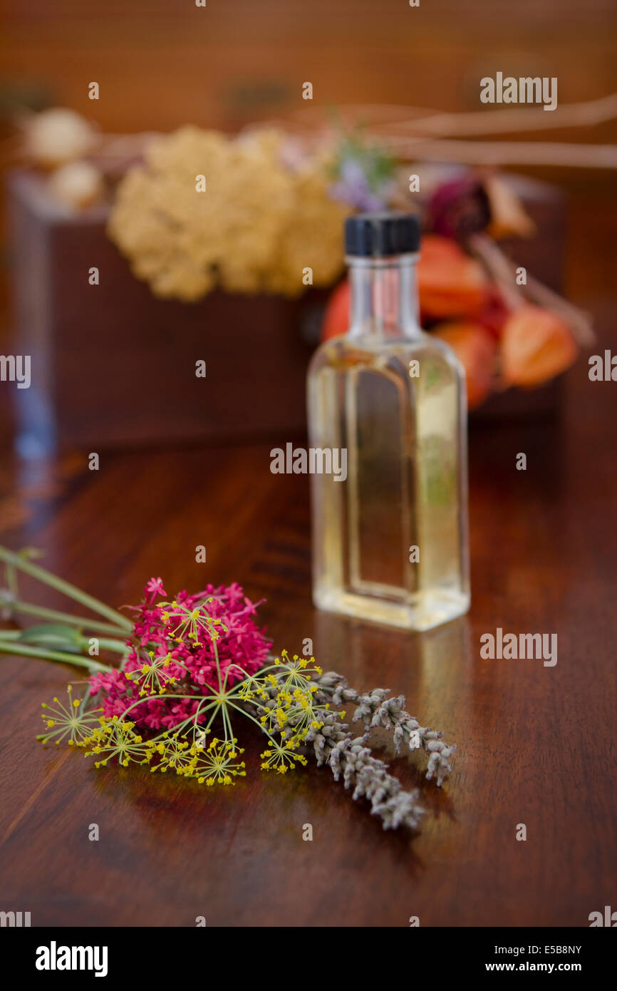 Ancora la vita della bottiglia di profumo di fiori su una superficie di legno. Foto Stock