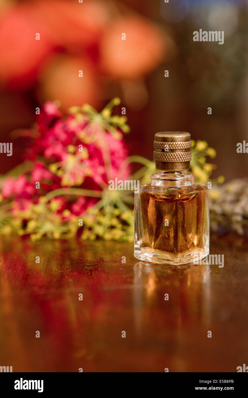 Ancora la vita della bottiglia di profumo di fiori su una superficie di legno. Foto Stock