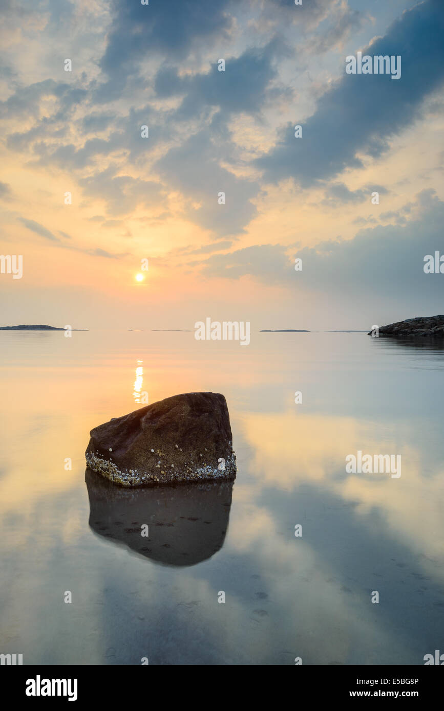 La riflessione di rock in oceano con drammatica sky Foto Stock