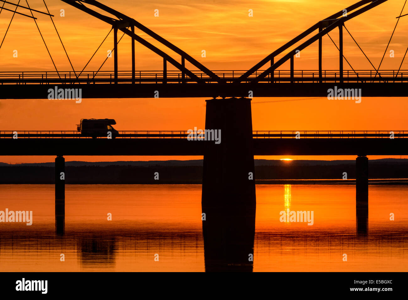 Silhouette del veicolo sul ponte sul fiume idilliaco Foto Stock