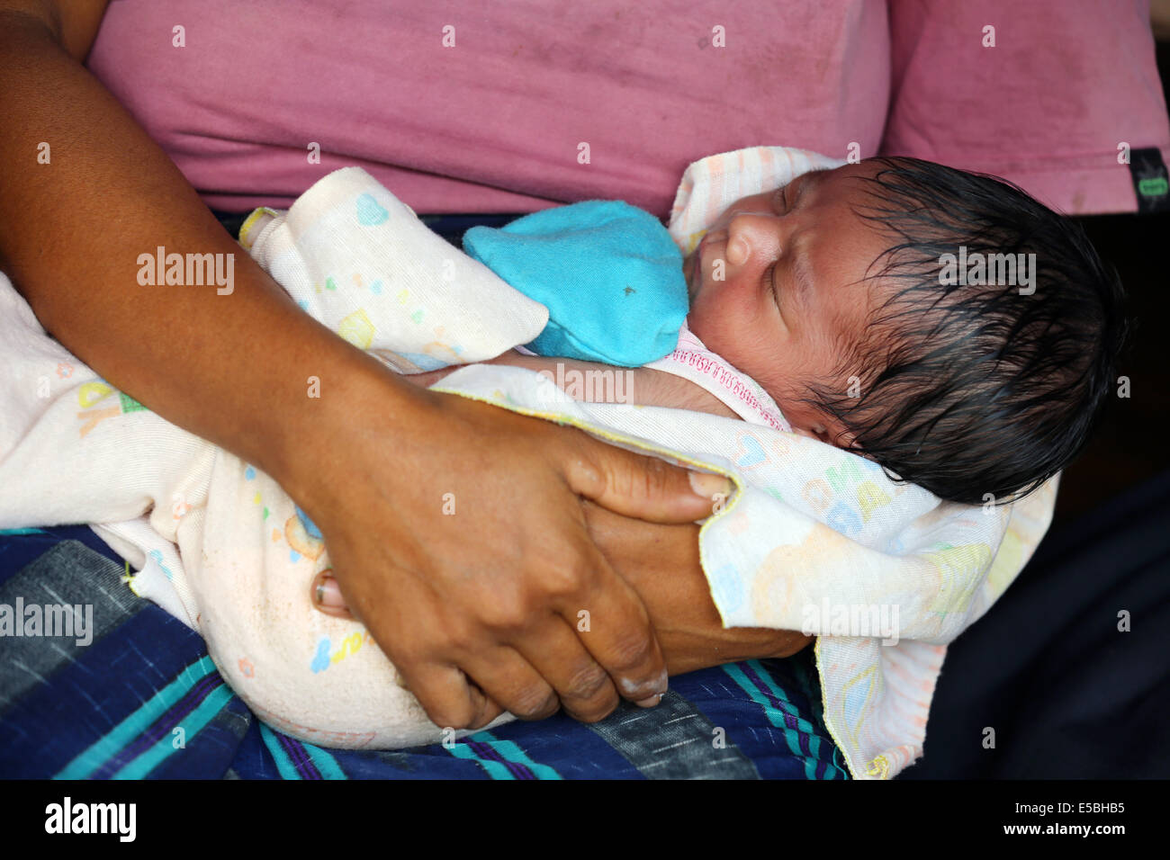Neonato (una settimana) dormire a sua madre di giro. Isola di Sumba, Indonesia, Asia Foto Stock
