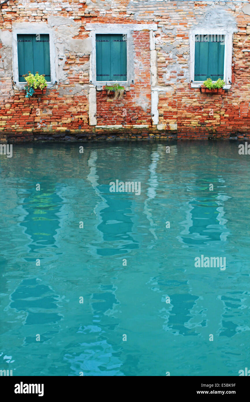 La riflessione di tre finestre sull'acqua a Venezia Foto Stock