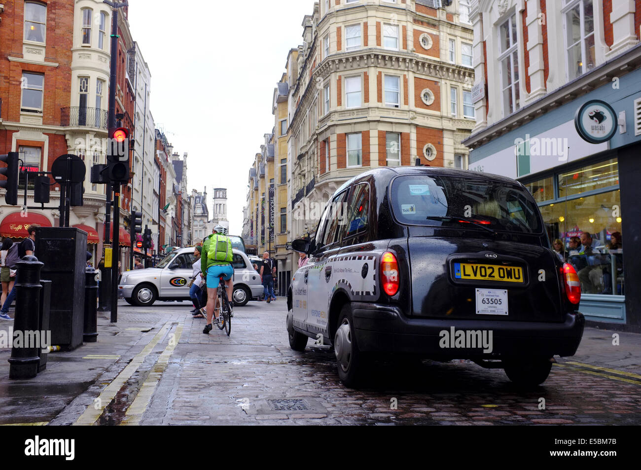 Taxi & ciclista in attesa al semaforo su Rupert Street, Londra Foto Stock