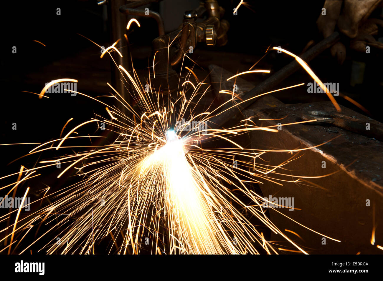 Un costruttore di metallo utilizzando una torcia a calore di un pezzo di metallo per dare forma a. Foto Stock