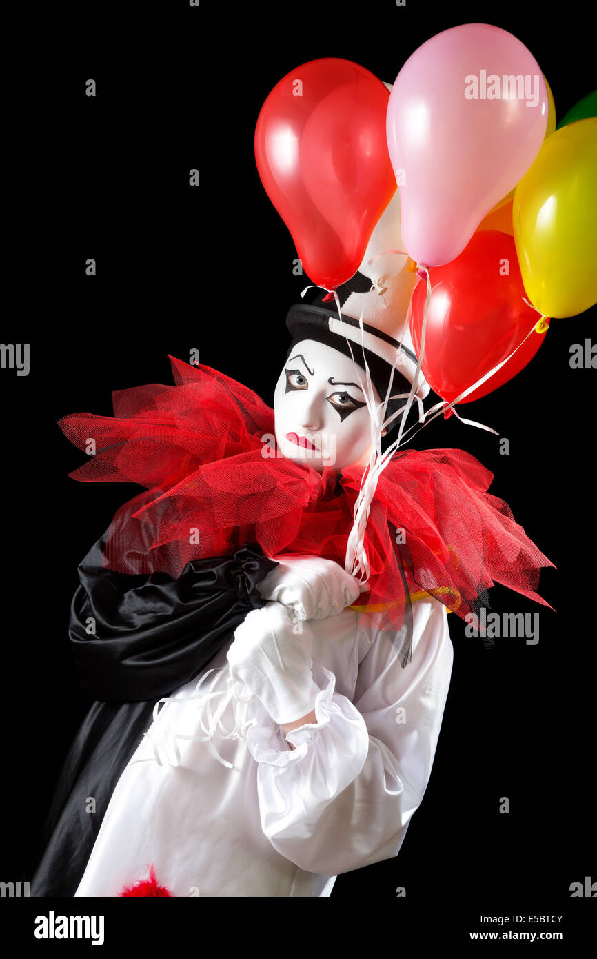 Femmina infelice Pierrot clown holding palloncini colorati Foto Stock