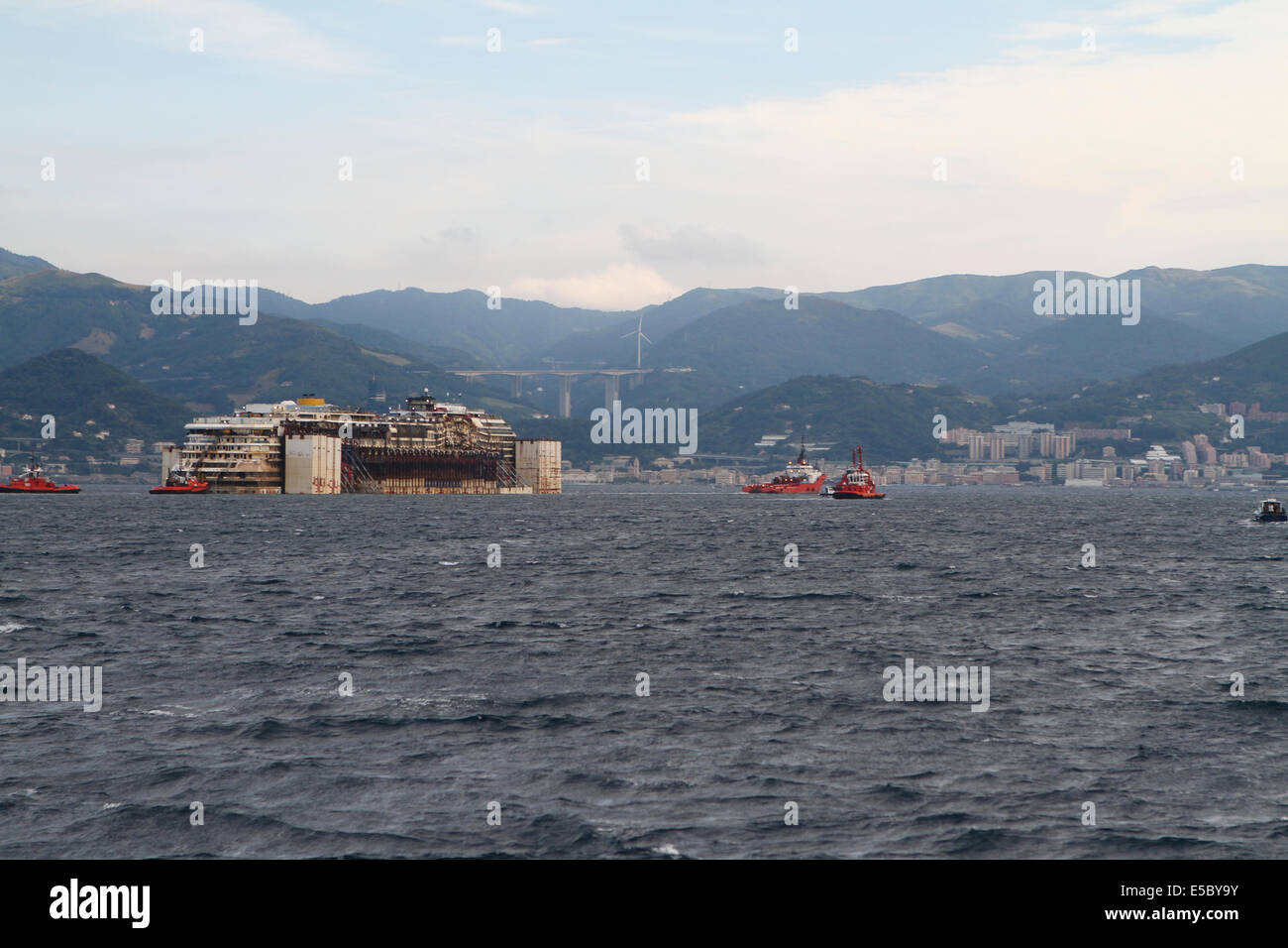 Genova, Italia. Il 27 luglio 2014. Costa Concordia naufragio è trainato verso il porto di Genova Prà-Voltri dove verrà scartato. Concordia ultimo viaggio iniziato mercoledì di luglio il ventitreesimo a Isola del Giglio dove la nave affondò nel gennaio 2012. Foto Stock