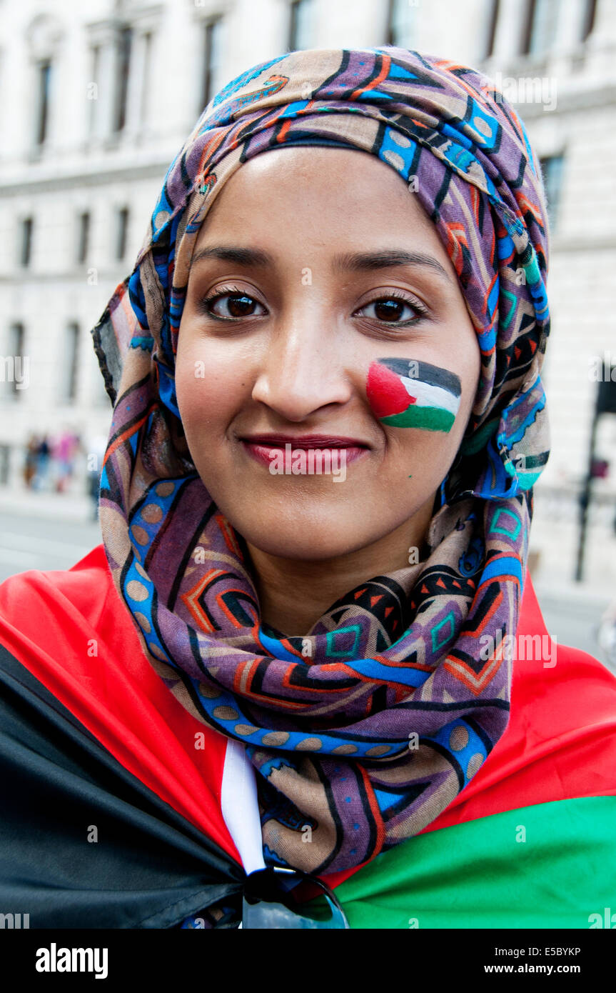 La dimostrazione contro il bombardamento israeliano della Striscia di Gaza, 26.07.2014. Una giovane donna ha una piccola bandiera palestinese dipinta sul suo viso Foto Stock